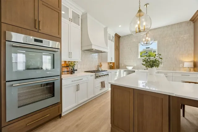 a bathroom with a bathtub sink vanity mirror and toilet