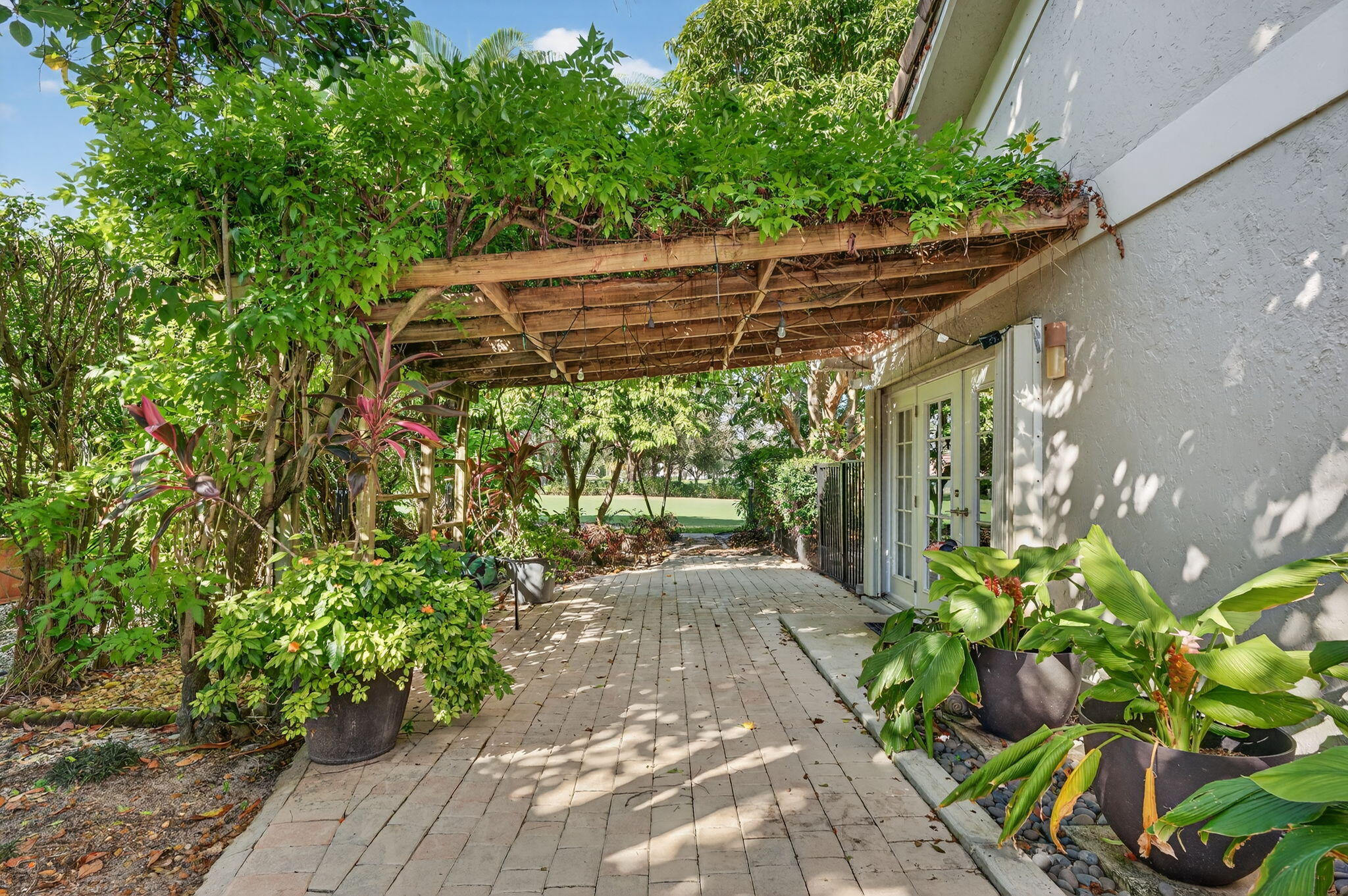 7205 Mandarin Drive Boca Raton, FL 33433 - Photo 44 of 71 a view of a patio with table and chairs and potted plants