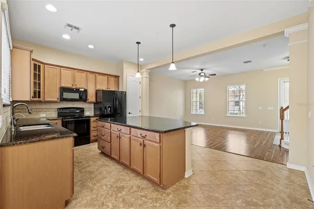 a kitchen with stainless steel appliances granite countertop a sink counter space cabinets and a wooden floor
