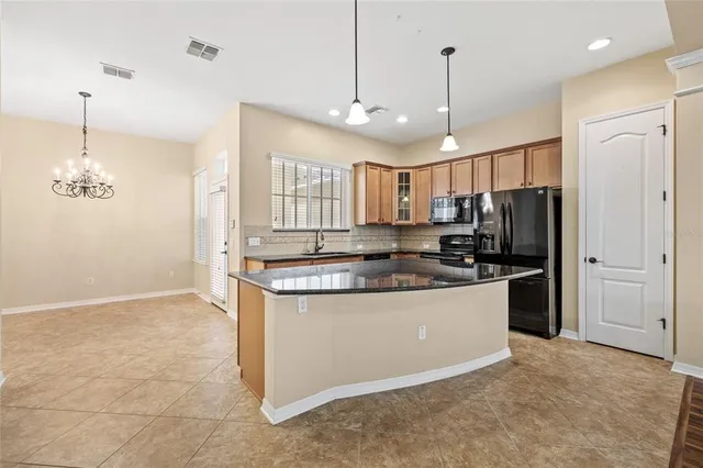 a kitchen with kitchen island a sink stainless steel appliances and cabinets