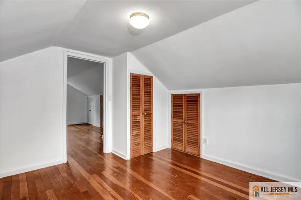 an empty room with wooden floor and closet