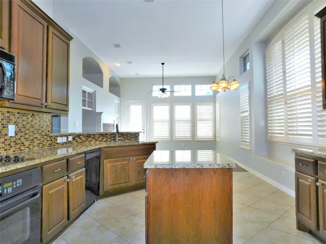 a large kitchen with stainless steel appliances granite countertop a stove and a sink