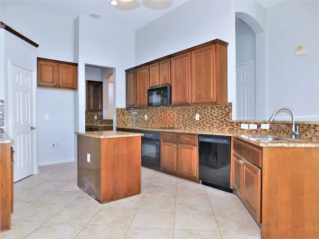 a kitchen with stainless steel appliances granite countertop a stove a sink and a microwave
