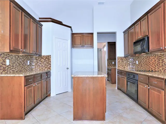 a kitchen with stainless steel appliances granite countertop a refrigerator and a stove
