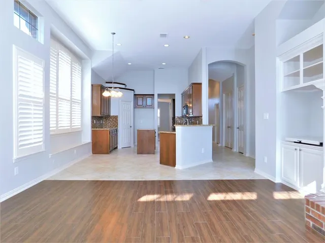 a view of a kitchen with refrigerator microwave and wooden floor