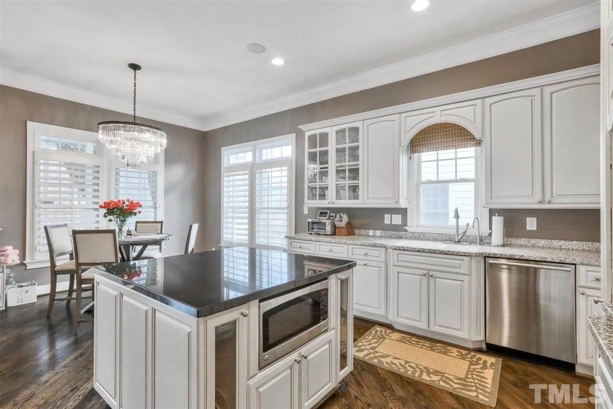 12317 Beestone Lane Raleigh, NC 27614 - Photo 13 of 30 a kitchen with granite countertop a stove and white cabinets