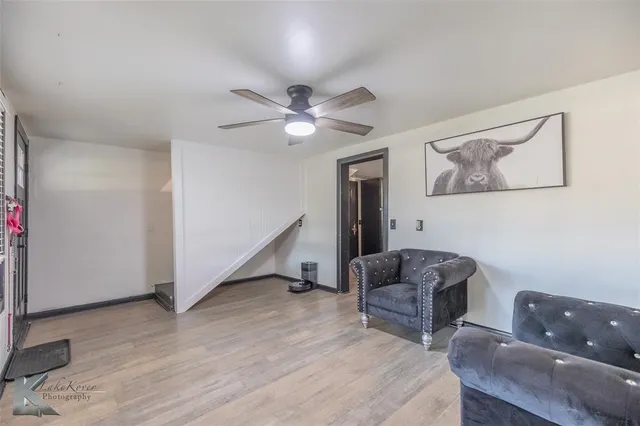 a living room with furniture and a ceiling fan