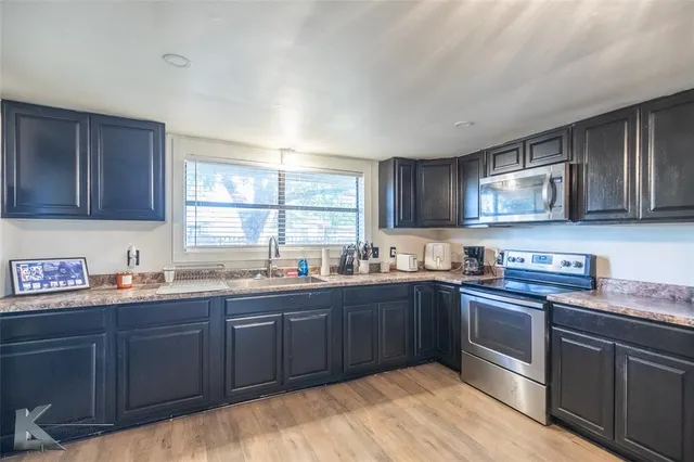 a kitchen with stainless steel appliances granite countertop a sink dishwasher stove and cabinets