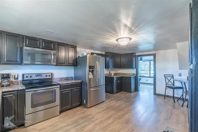 a kitchen with a stove a refrigerator and a microwave