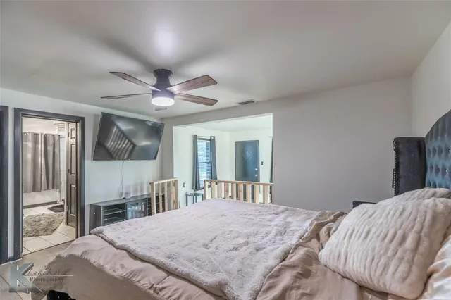 a bedroom with a bed dresser and a large window