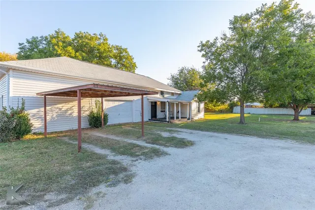 a view of a house with a yard and tree s