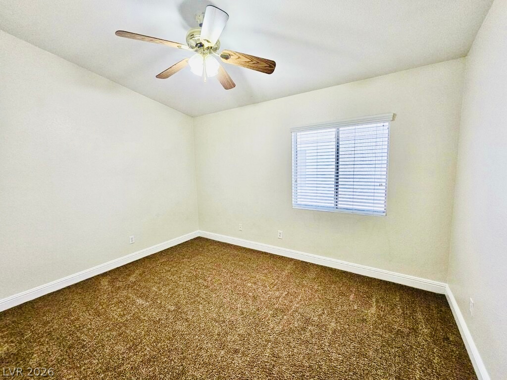 5953 Crumbling Ridge Street Henderson, NV 89011 - Photo 32 of 42 A versatile room features a window with blinds and plush carpet, ready for personalization.