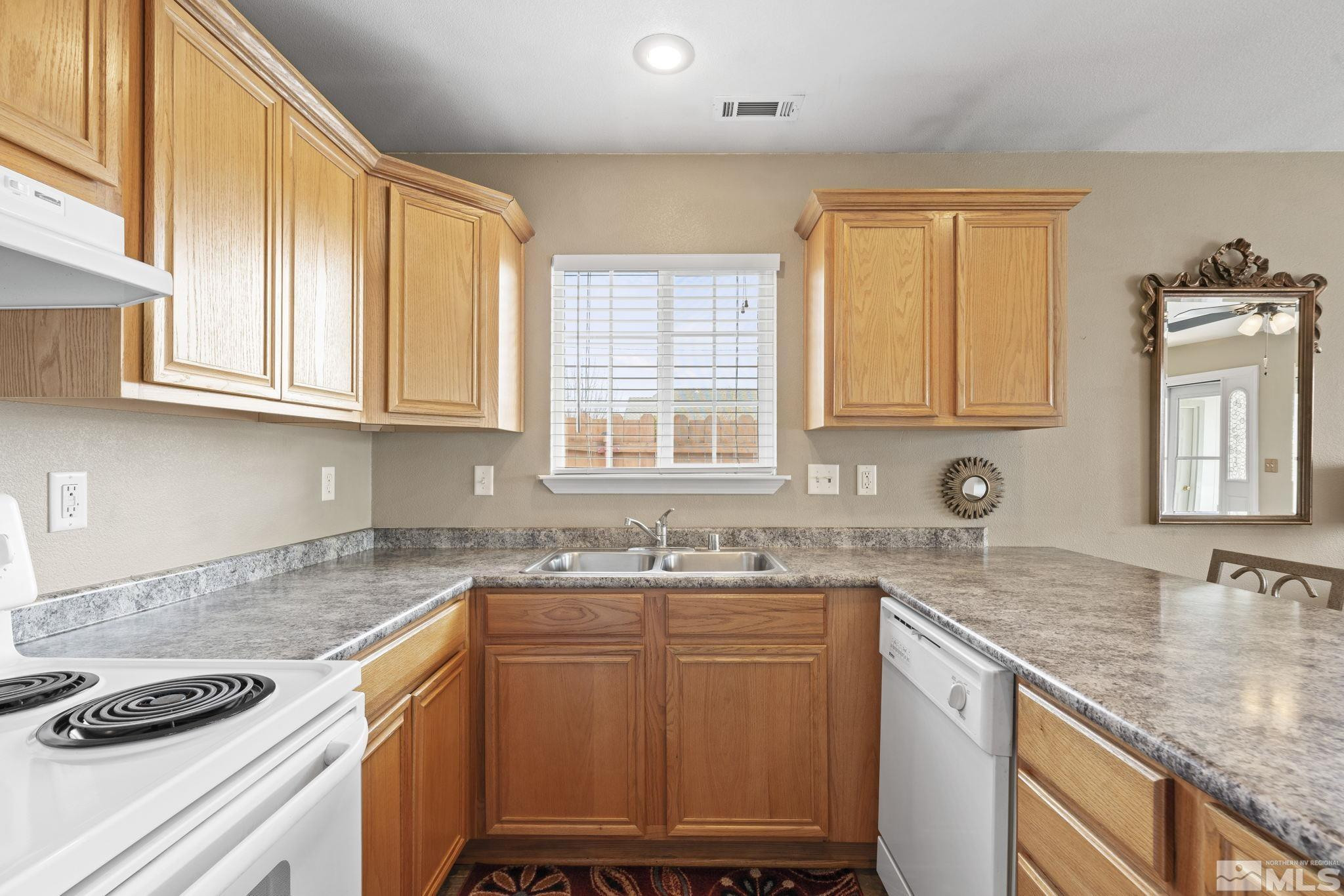 595 Roberts Street Reno, NV 89502 - Photo 13 of 24 a kitchen with granite countertop a sink stove and cabinets