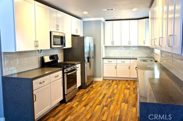 a view of a room with wooden floor and white walls
