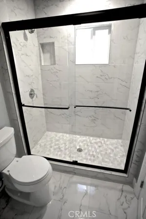 a view of a room with wooden floor and bathroom