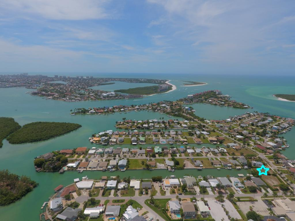 147 Capri Naples Naples, FL 34113 - Photo 4 of 19 an aerial view of a city with lots of residential buildings ocean and mountain view in back