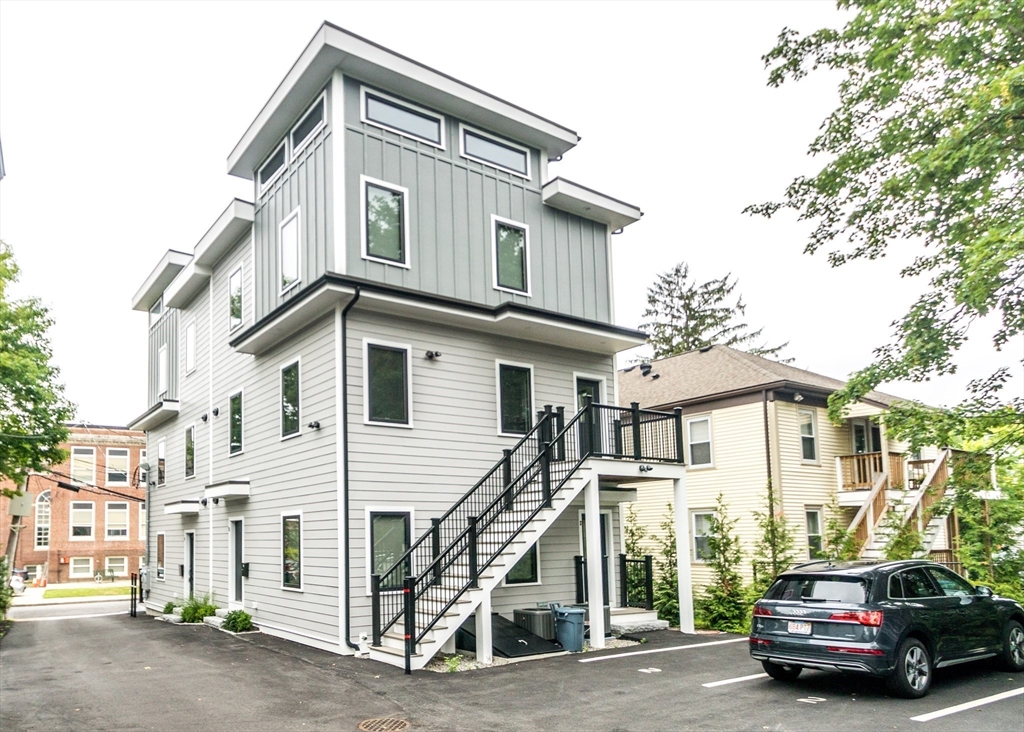 15 Alder Street, Unit 1 Waltham, MA 02453 - Photo 30 of 38 a car parked in front of a white house
