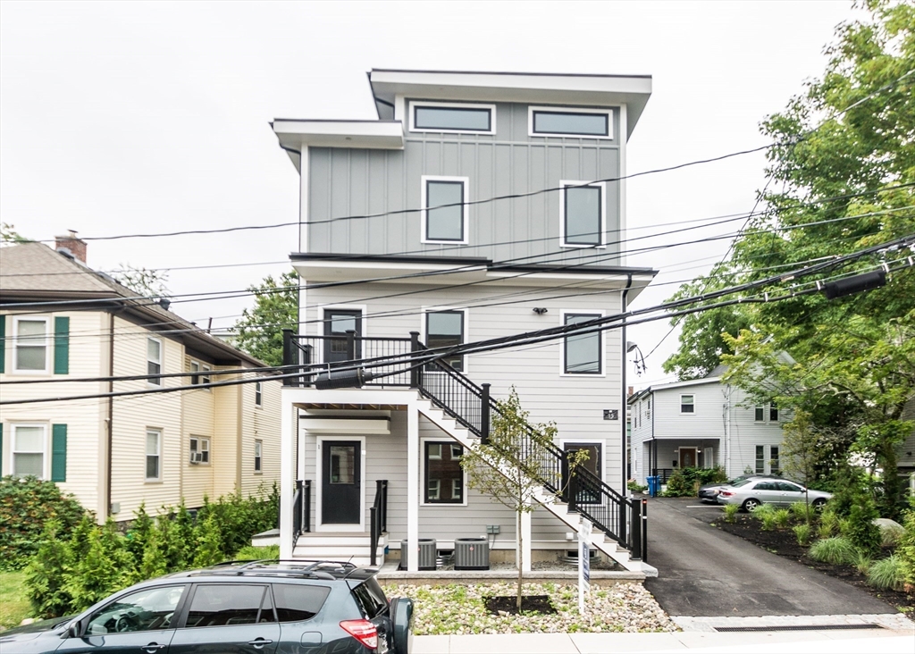 15 Alder Street, Unit 1 Waltham, MA 02453 - Photo 3 of 38 a view of a white building among the street with palm trees