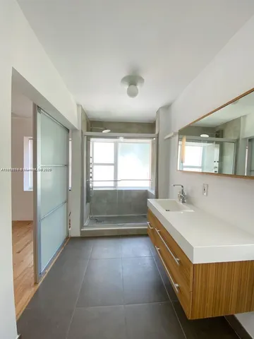 a bathroom with a tub sink and mirror
