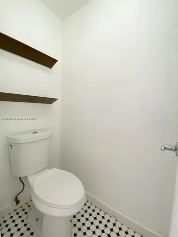 a white toilet sitting next to a shower