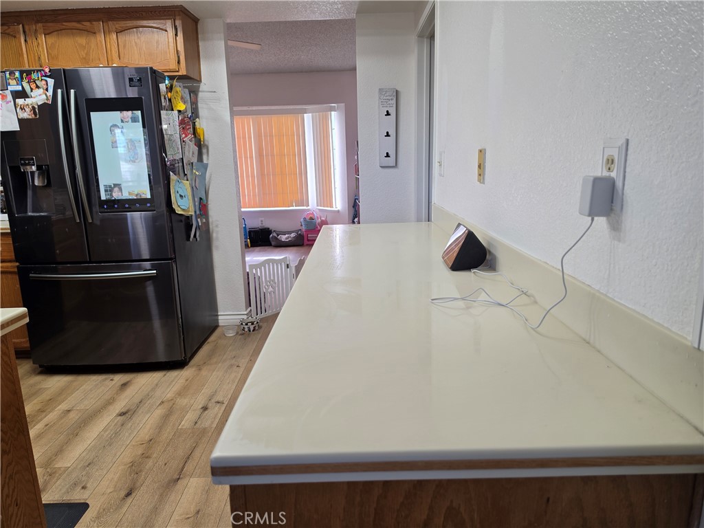 13502 Cuyamaca Road Apple Valley, CA 92308 - Photo 11 of 15 a living room with a bed and a refrigerator