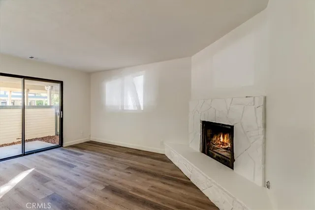 a view of empty room with wooden floor and fireplace
