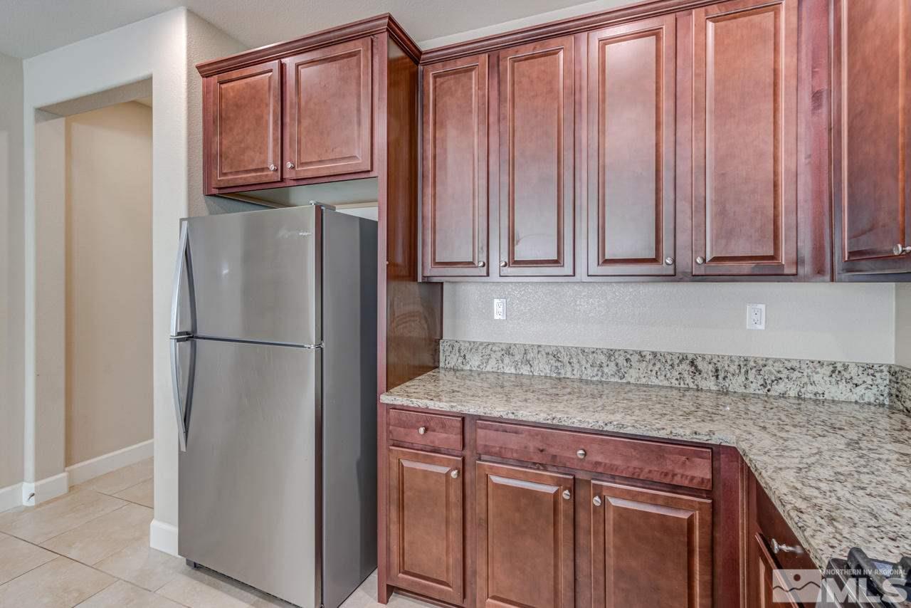 9728 Pachuca Drive Reno, NV 89521 - Photo 8 of 25 a kitchen with stainless steel appliances granite countertop a refrigerator and a sink