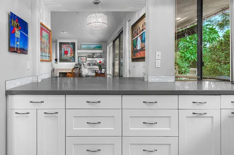 a kitchen with granite countertop white cabinets and window