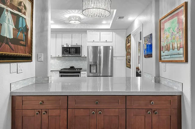 a kitchen with stainless steel appliances granite countertop a refrigerator a stove and a sink