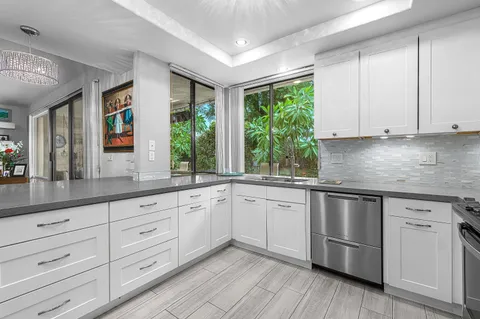 a kitchen with granite countertop white cabinets and white appliances