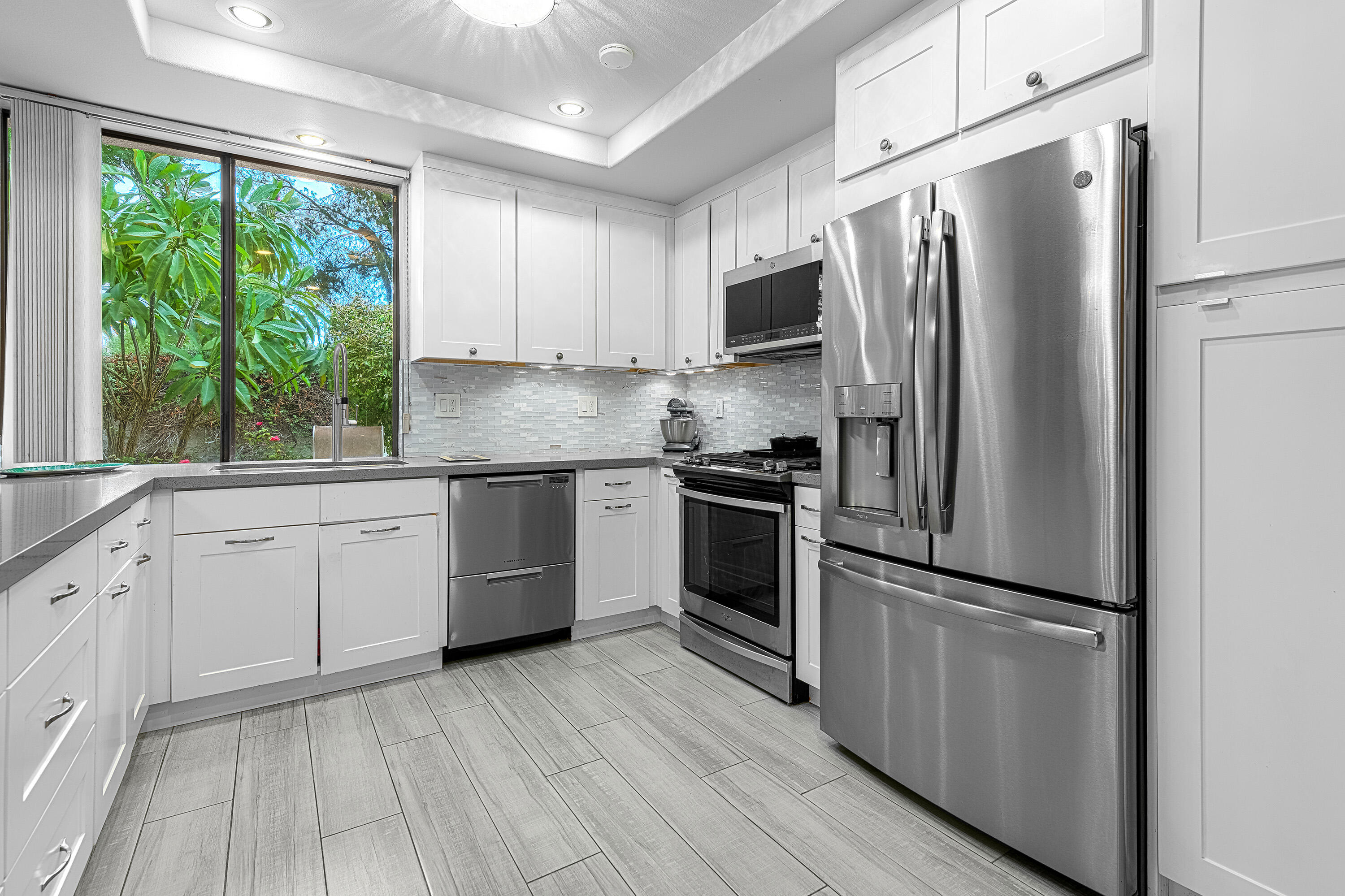2264 Oakcrest Drive Palm Springs, CA 92264 - Photo 9 of 19 a kitchen with white cabinets stainless steel appliances and window