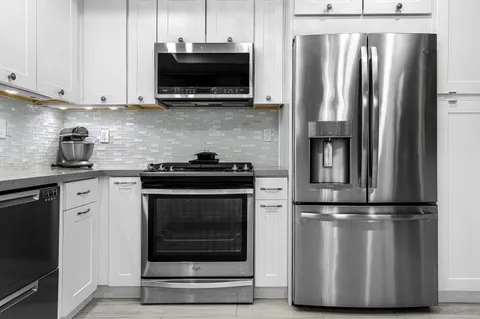 a kitchen with stainless steel appliances granite countertop a refrigerator stove and microwave