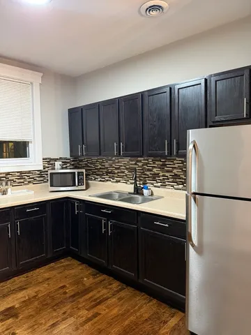 a kitchen with wooden cabinets and white stainless steel appliances