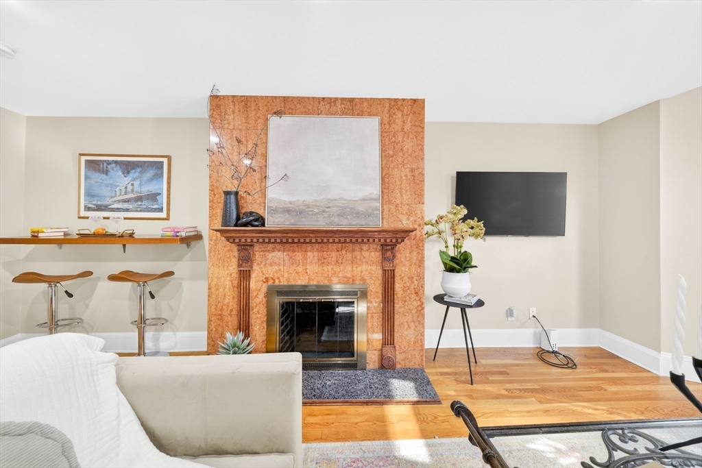 352 Tappan Street, Unit 1 Brookline, MA 02445 - Photo 5 of 42 a living room with furniture a flat screen tv and a fireplace