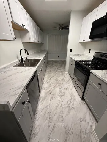 a kitchen with stainless steel appliances granite countertop a sink and a stove