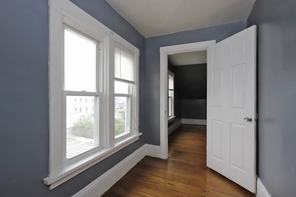 50-52 Rivet Street, Unit 2 New Bedford, MA 02744 - Photo 4 of 6 a view of hallway with a large window and wooden floor