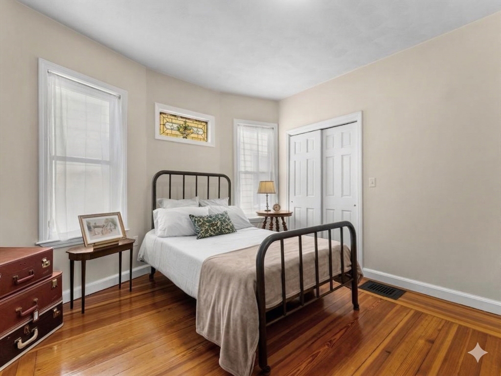 11 Doris Street, Unit 1 Boston, MA 02125 - Photo 10 of 17 a bedroom with a bed a dresser and wooden floor