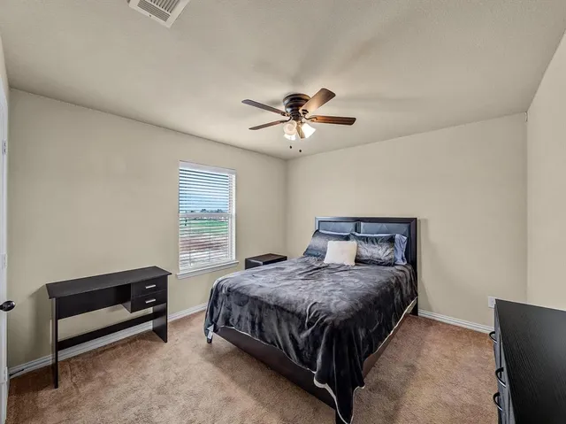 a bedroom with a bed and a ceiling fan