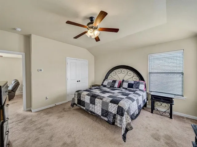 a spacious bedroom with a bed and a dresser