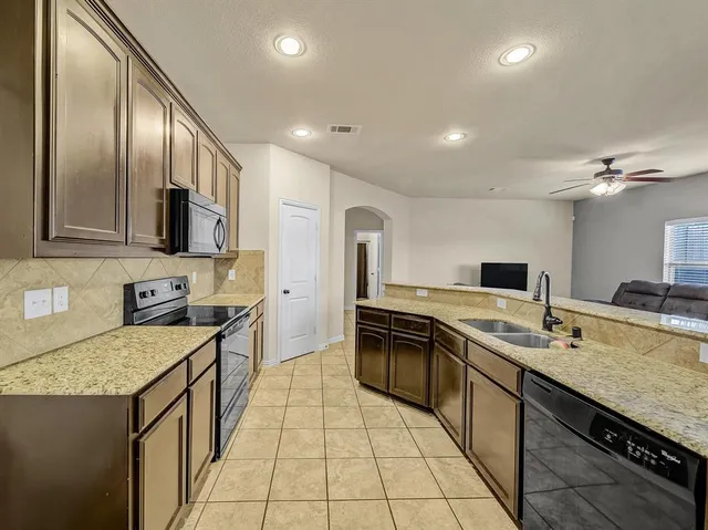 a large kitchen with a large counter top and stainless steel appliances