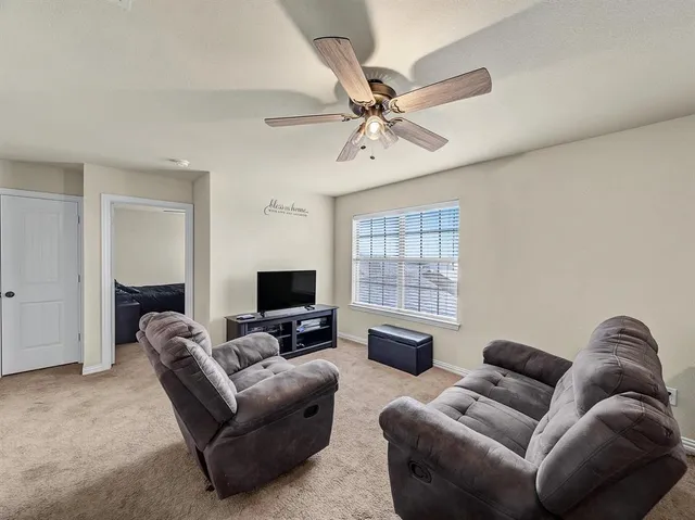 a living room with furniture ceiling fan and a window