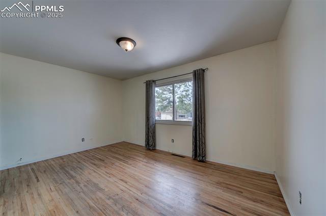 6773 Dale Road Colorado Springs, CO 80915 - Photo 25 of 45 Empty room featuring visible vents and light wood-type flooring