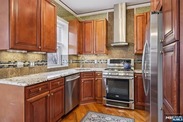a kitchen with stainless steel appliances granite countertop a stove a sink and a refrigerator