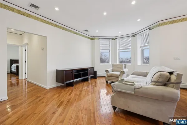 a living room with furniture and a wooden floor