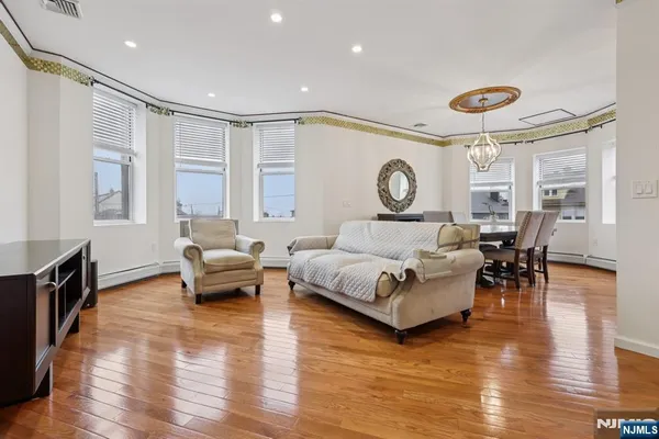 a dining room with furniture a chandelier and wooden floor