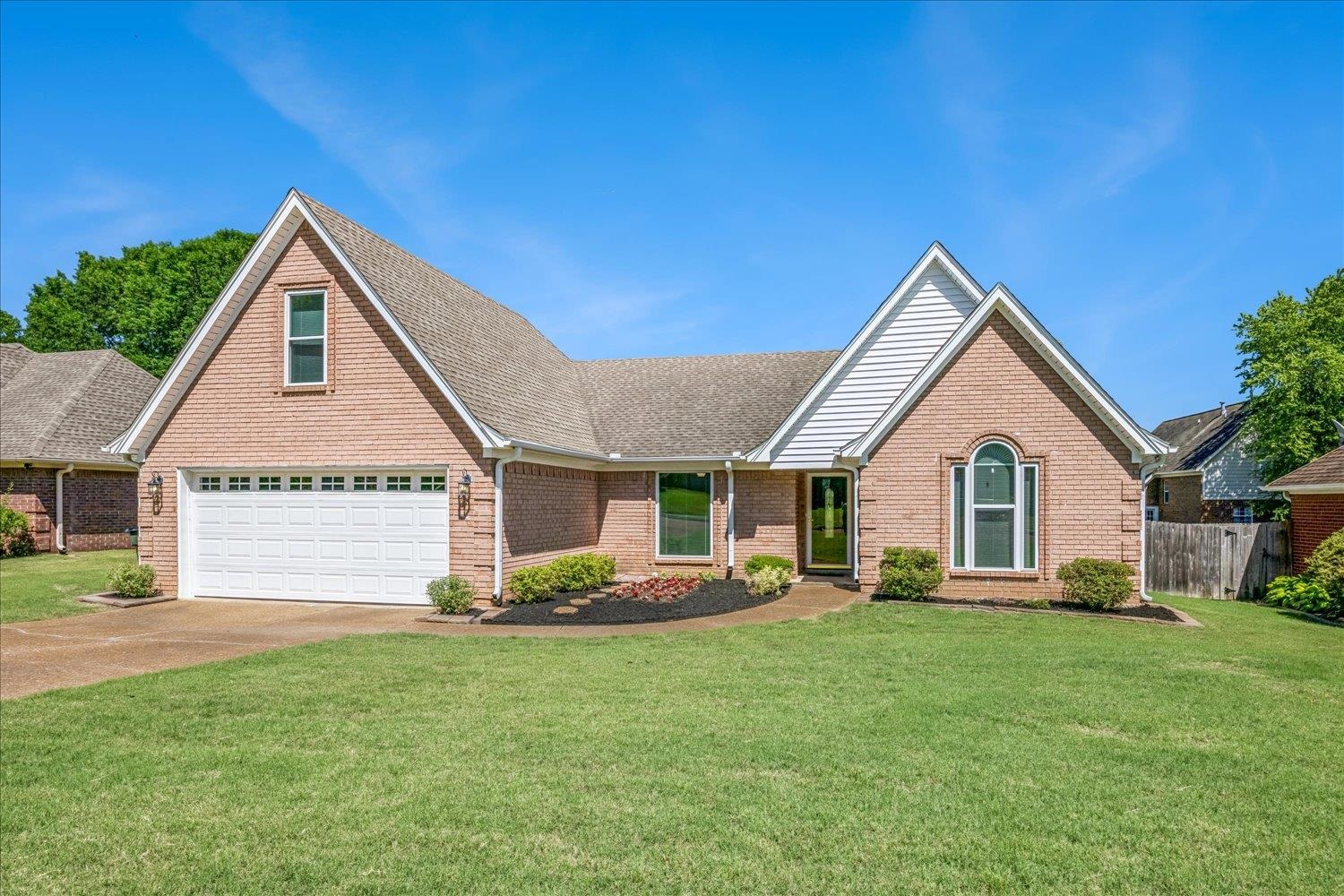 4654 Shadow Wick Lane Bartlett, TN 38002 - Photo 1 of 26 Brick exterior with white trim, featuring a two-car garage with a panel door