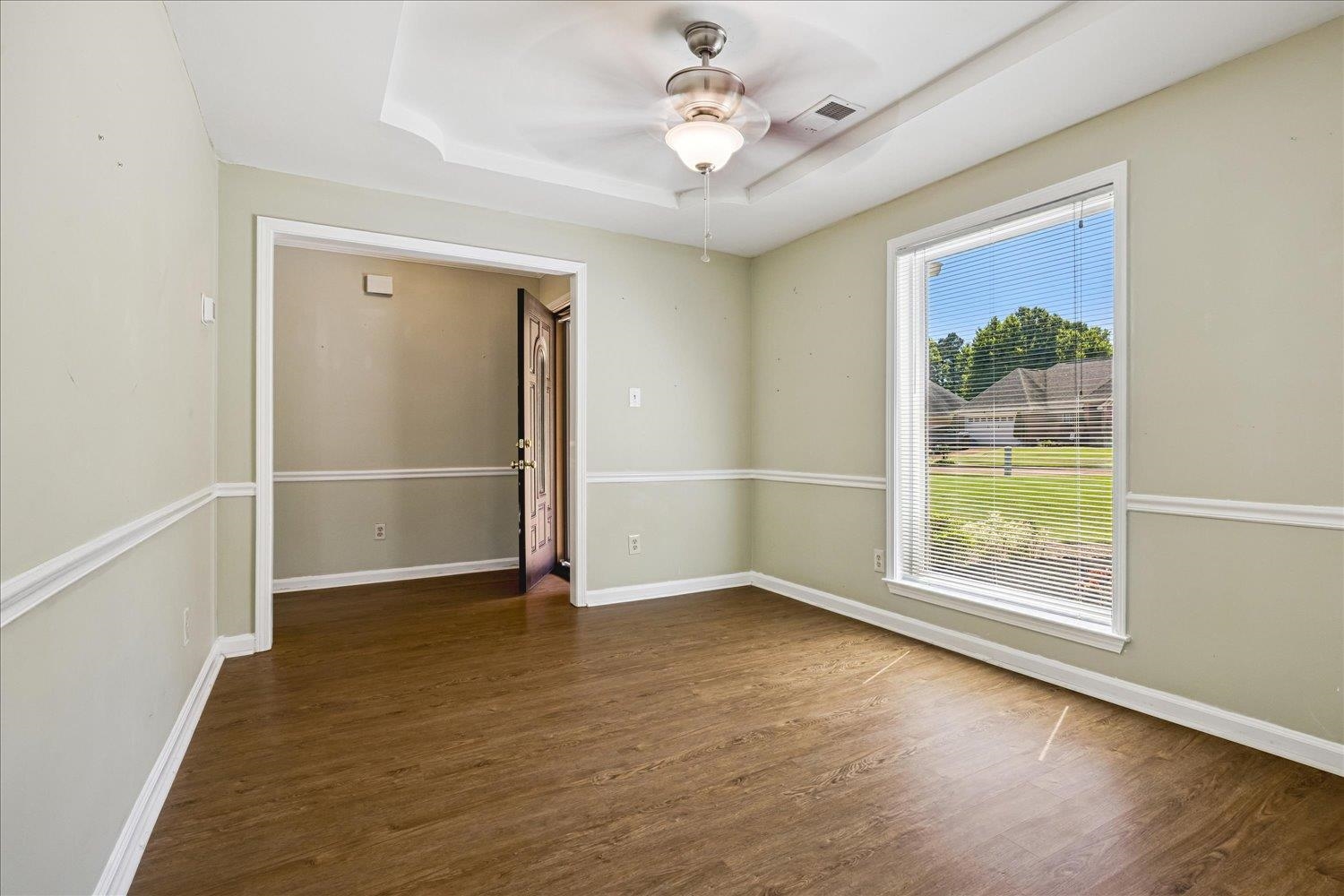 4654 Shadow Wick Lane Bartlett, TN 38002 - Photo 14 of 26 Room with wood-finish flooring, tray ceiling, and a ceiling fan with light fixture