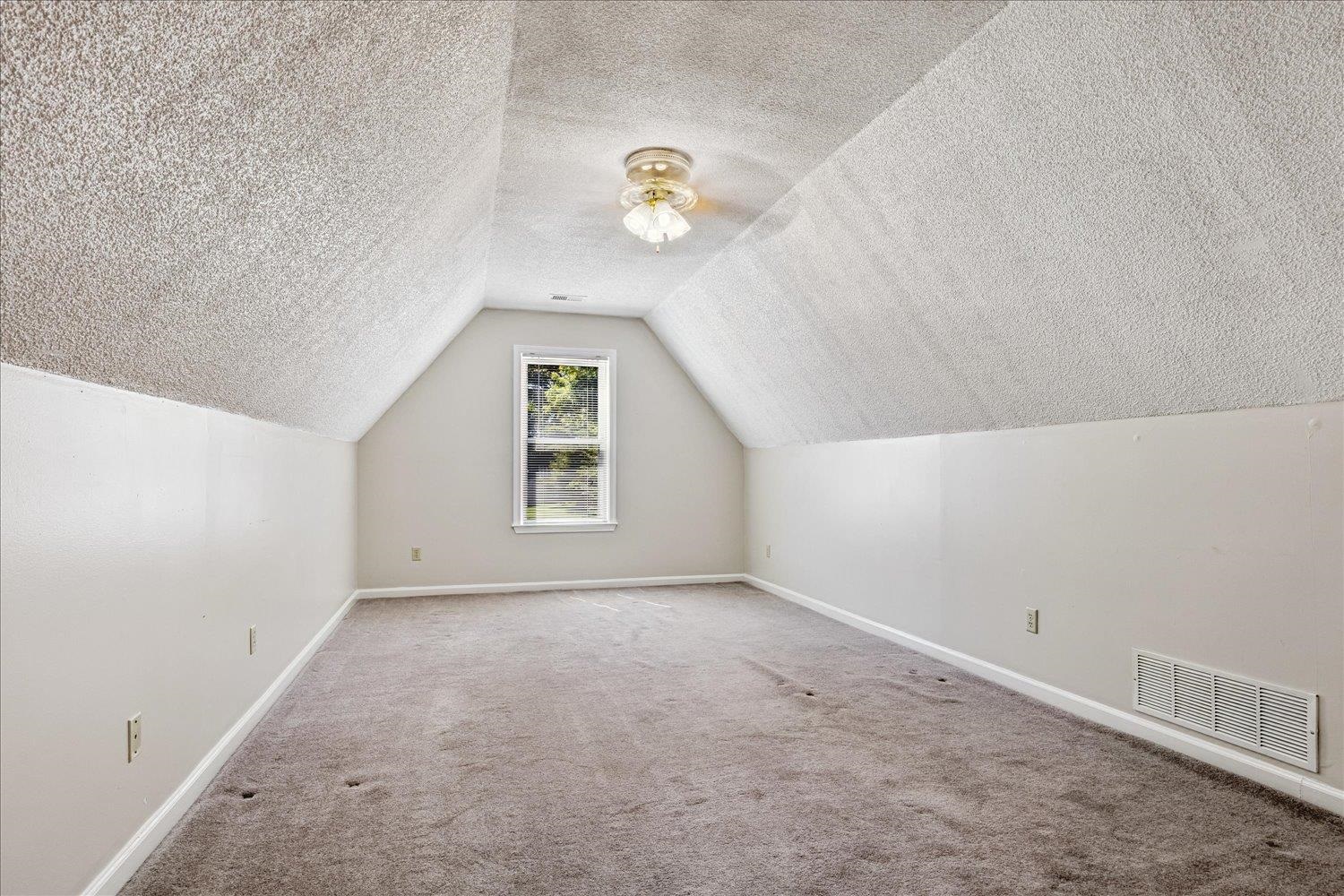 4654 Shadow Wick Lane Bartlett, TN 38002 - Photo 22 of 26 Carpeted attic space featuring a single window, sloped walls, a ceiling-mounted light fixture, and baseboard trim