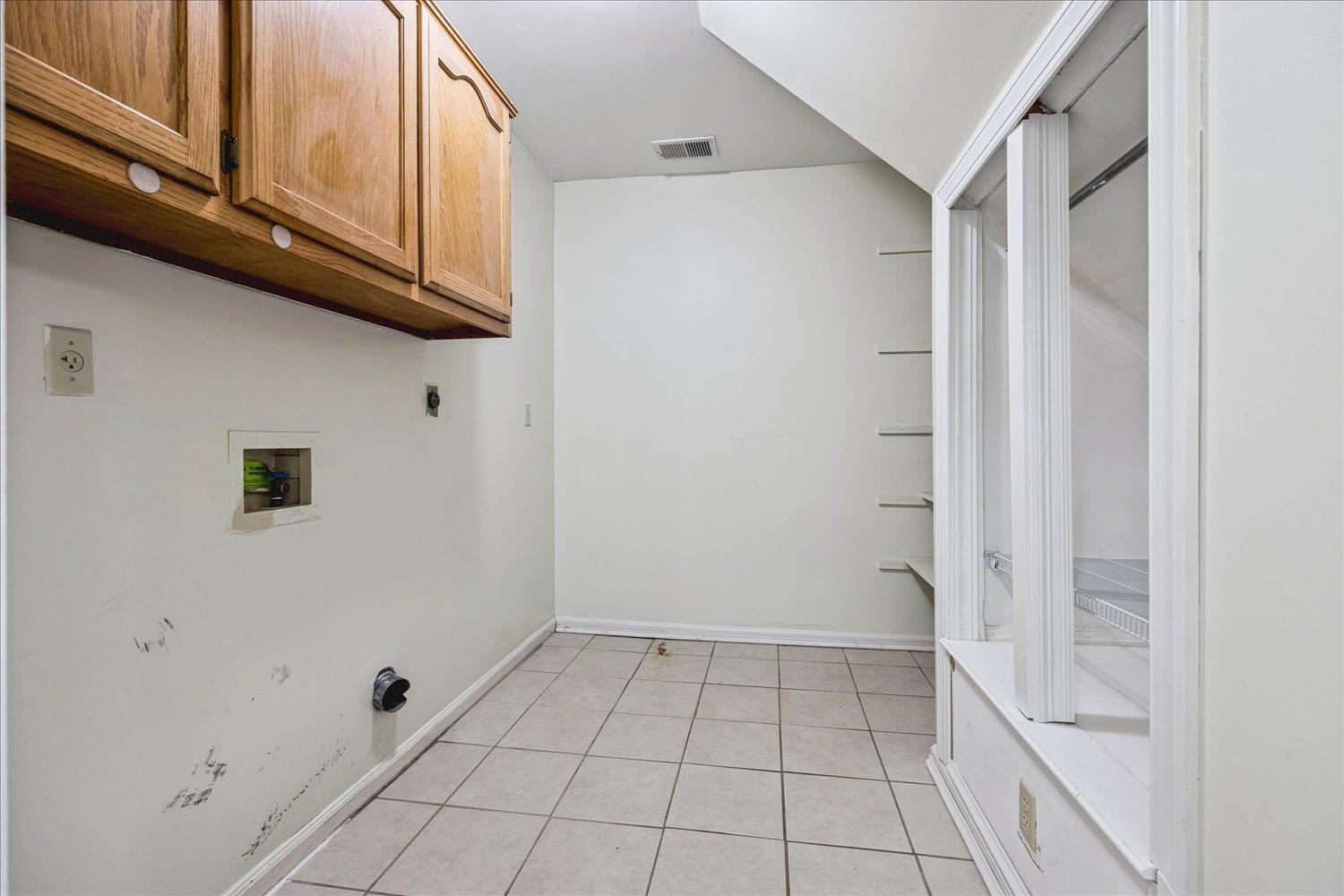 4654 Shadow Wick Lane Bartlett, TN 38002 - Photo 23 of 26 Utility room featuring ceramic tile flooring, wood-finish cabinetry, and built-in shelving