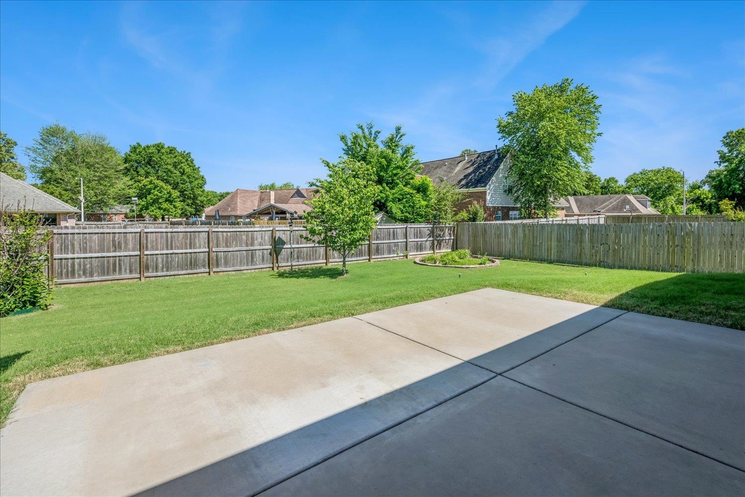 4654 Shadow Wick Lane Bartlett, TN 38002 - Photo 25 of 26 Spacious backyard featuring a large concrete patio, manicured lawn, and privacy fencing
